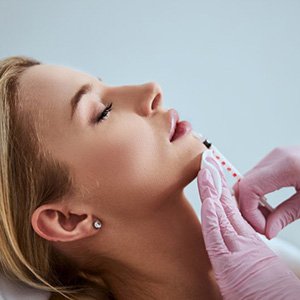 a woman receiving dermal fillers from her dentist