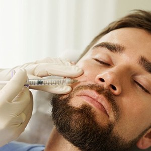 a man receiving dermal fillers from his dentist